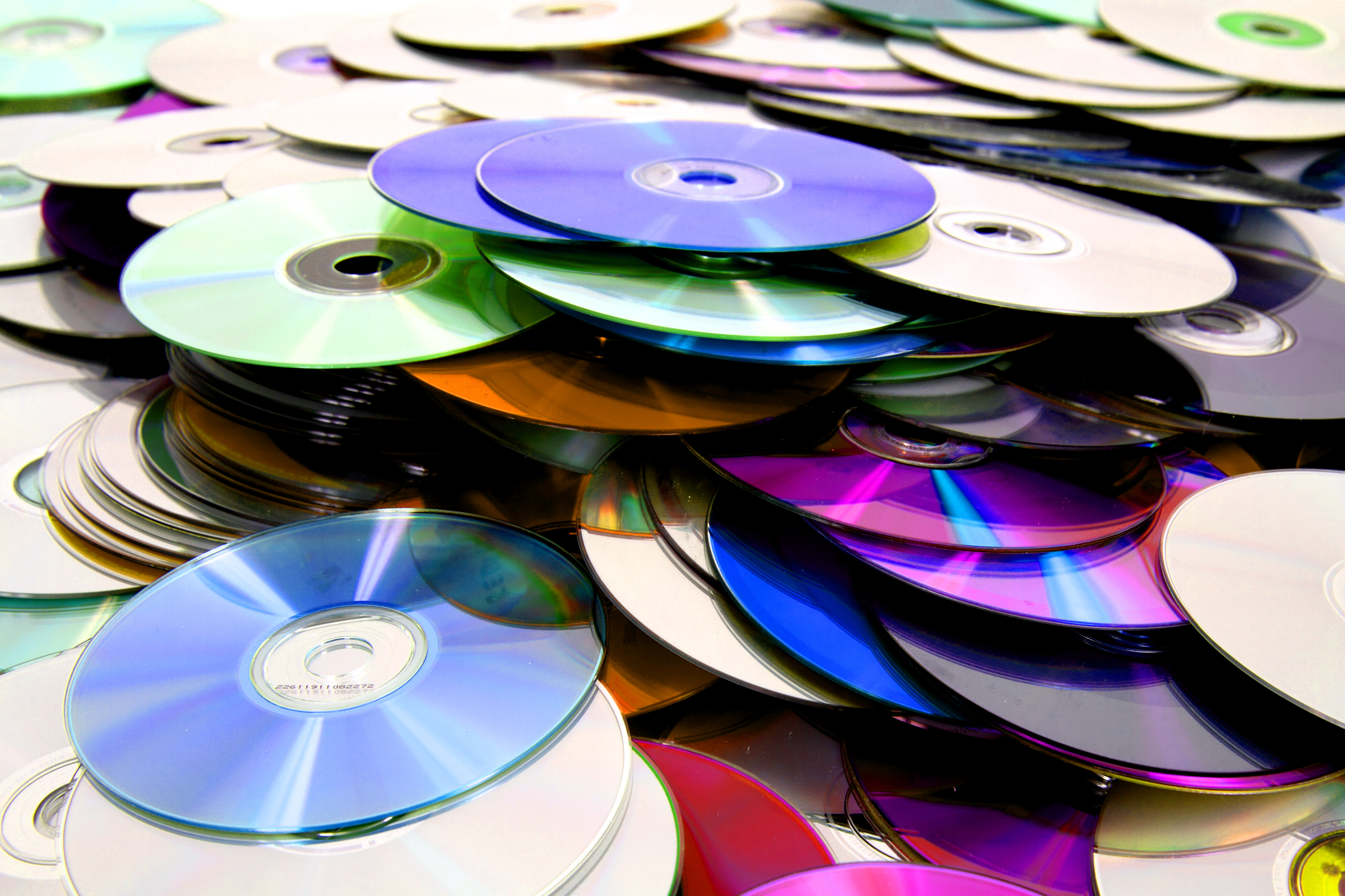 Много использованных дисков. Компакт диск. СД И двд диски. Оптический диск. Много дисков.