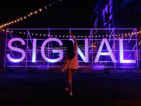 Девушка на фоне логотипа фестиваля Signal