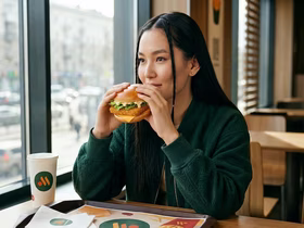 Девушка ест бургер в сети «Вкусно — и точка»