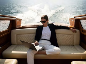 Девушка сидит с ноутбуком в яхте