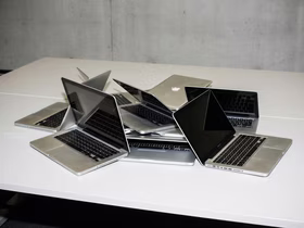 Несколько ноутбуков беспорядочно лежат на столе