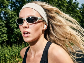 Девушка бегает в спортивном костюме и солнцезащитных очках