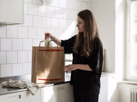 Девушка в комнате с пакетом