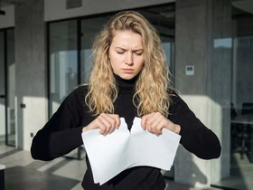 девушка рвёт бумагу