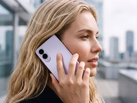 Девушка со светлыми волосами разговаривает по смартфону Samsung Galaxy Z Fold8 лавандового цвета