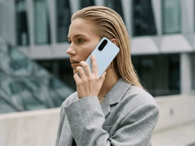 Девушка держит у уха смартфон Samsung Galaxy A18