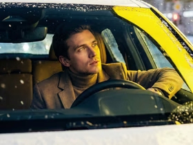 молодой человек сидит в машине