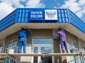 Мужчины реставрируют здание Почты России