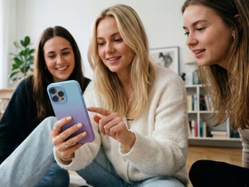 Три девушки смотрят в смартфон