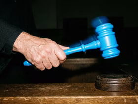 Голубой молоток у судьи в руках