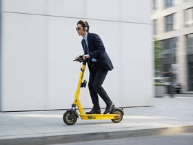 Мужчина едет на электросамокате Яндекс Go