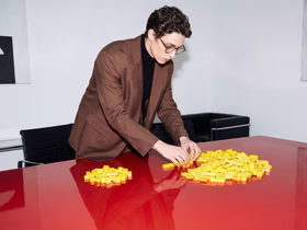 Человек собирает конструктор на столе