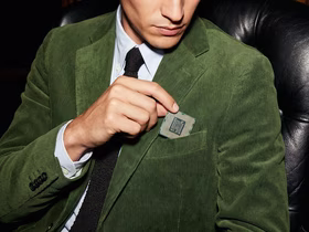 Мужчина вкладывает кусочек ткани в виде компьютерного чипа в нагрудный карман пиджака