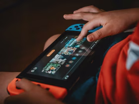 Игровая приставка лежит в руках ребёнка