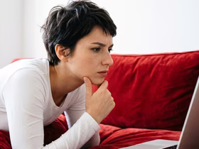 Девушка хмурится и смотрит в ноутбук