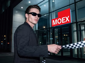Парень в солнцезащитных очках протягиевает ленту рядом с офисом MOEX