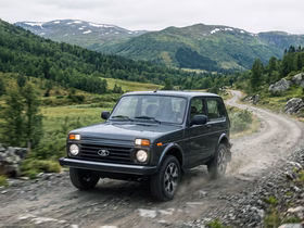 Lada Niva Legend едет по грунтовой дороге в горах
