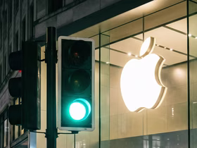 Зеленый светофор на фоне большого логотипа Apple