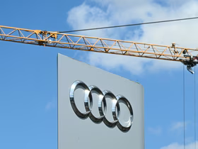 Логотип Audi на фоне голубого неба и подъёмного крана