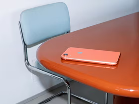 Оранжевый iPhone лежит на оранжевом столе