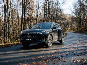 Changan UNI-Z едет по дороге через осенний лес