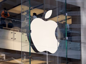 Логотип Apple на стеклянной стене современного здания