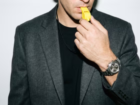 Мужчина свистит в свисток