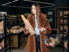 Женщина с корзиной для покупок в магазине