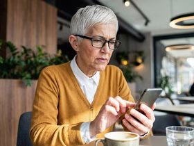 Взрослая женщина смотрит в телефон