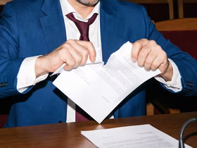 Мкжчина рвет бумагу