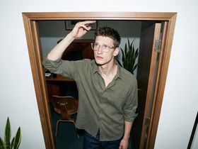 Мужчина достаёт рукой до верхнего косяка двери