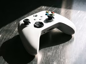 Белый геймпад Xbox лежит на металлической поверхности