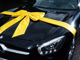 Капот черной машины обмотан желтой лентой