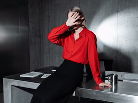 Девушка загораживается рукой от света