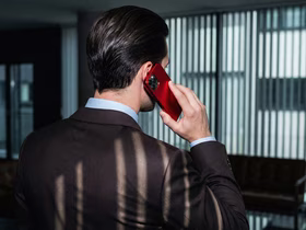 Мужчина в деловом костюме разговаривает по телефону