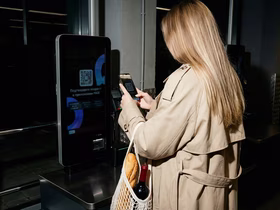 Девушка у кассы самообслуживания подтверждает свой возраст через мессенджер Max