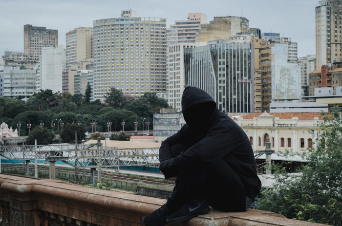мужчина со скрытым лицом на фоне городского пейзажа