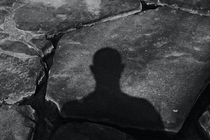 тень мужчины на каменной поверхности