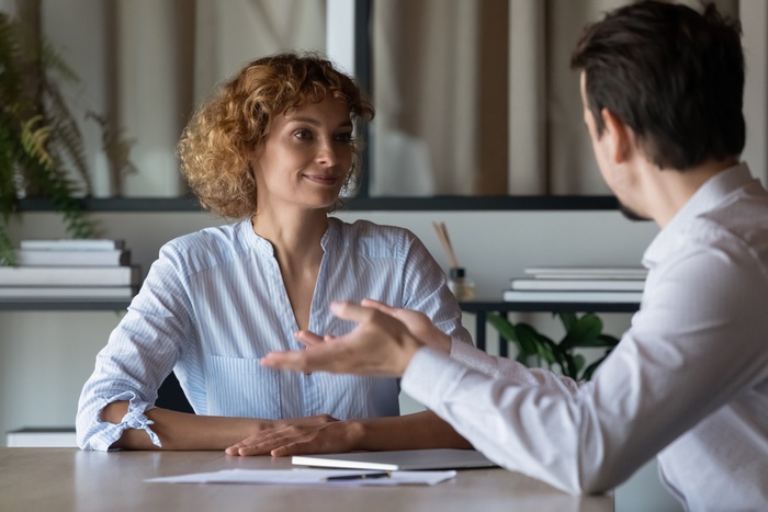 собеседование в позитивной атмосфере, мужчина и женщина общаются за столом в офисе